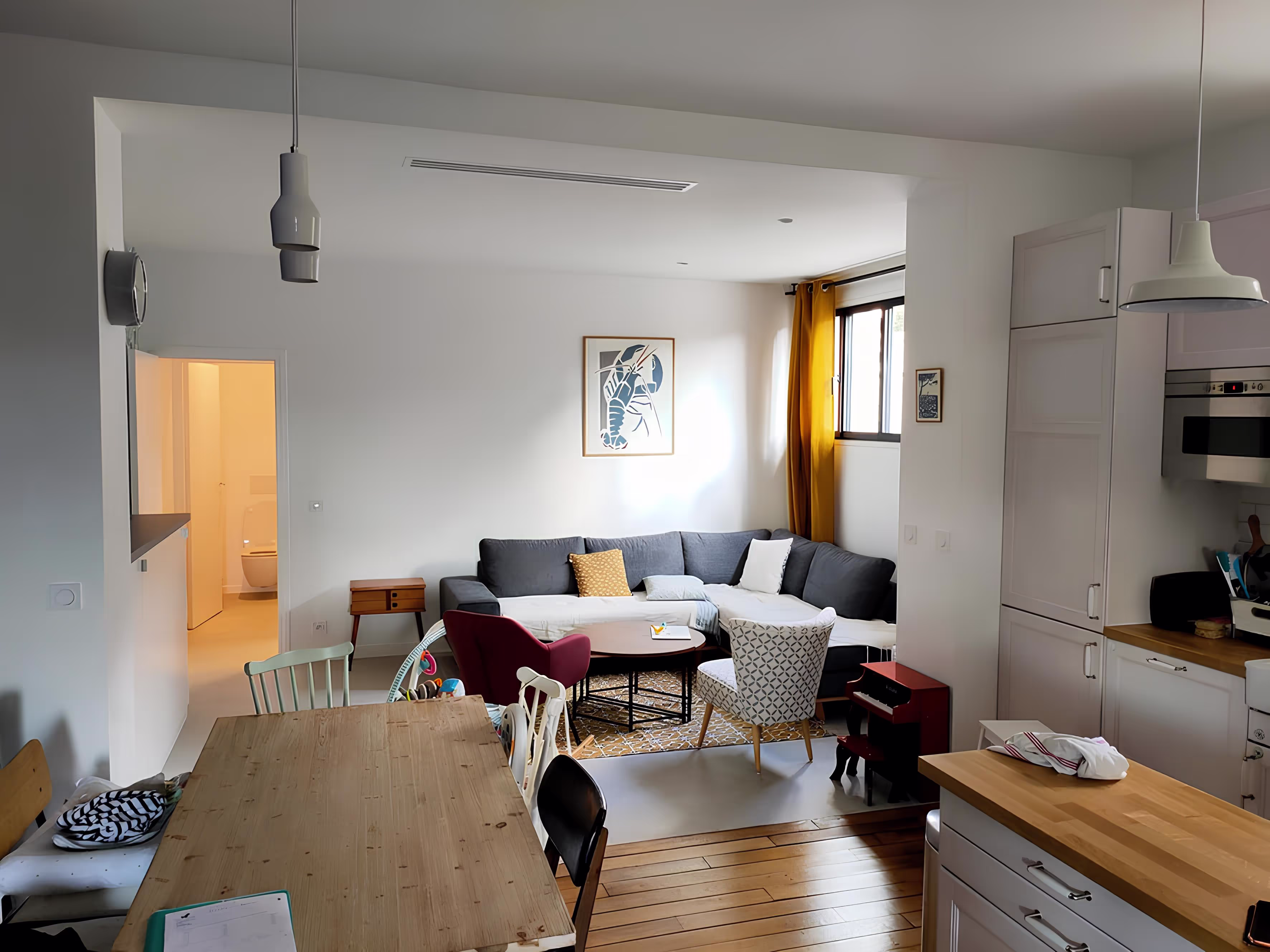 Salon contemporain avec cuisine ouverte, extension Lasègue à Châtillon, conçue par SINA Architecture.