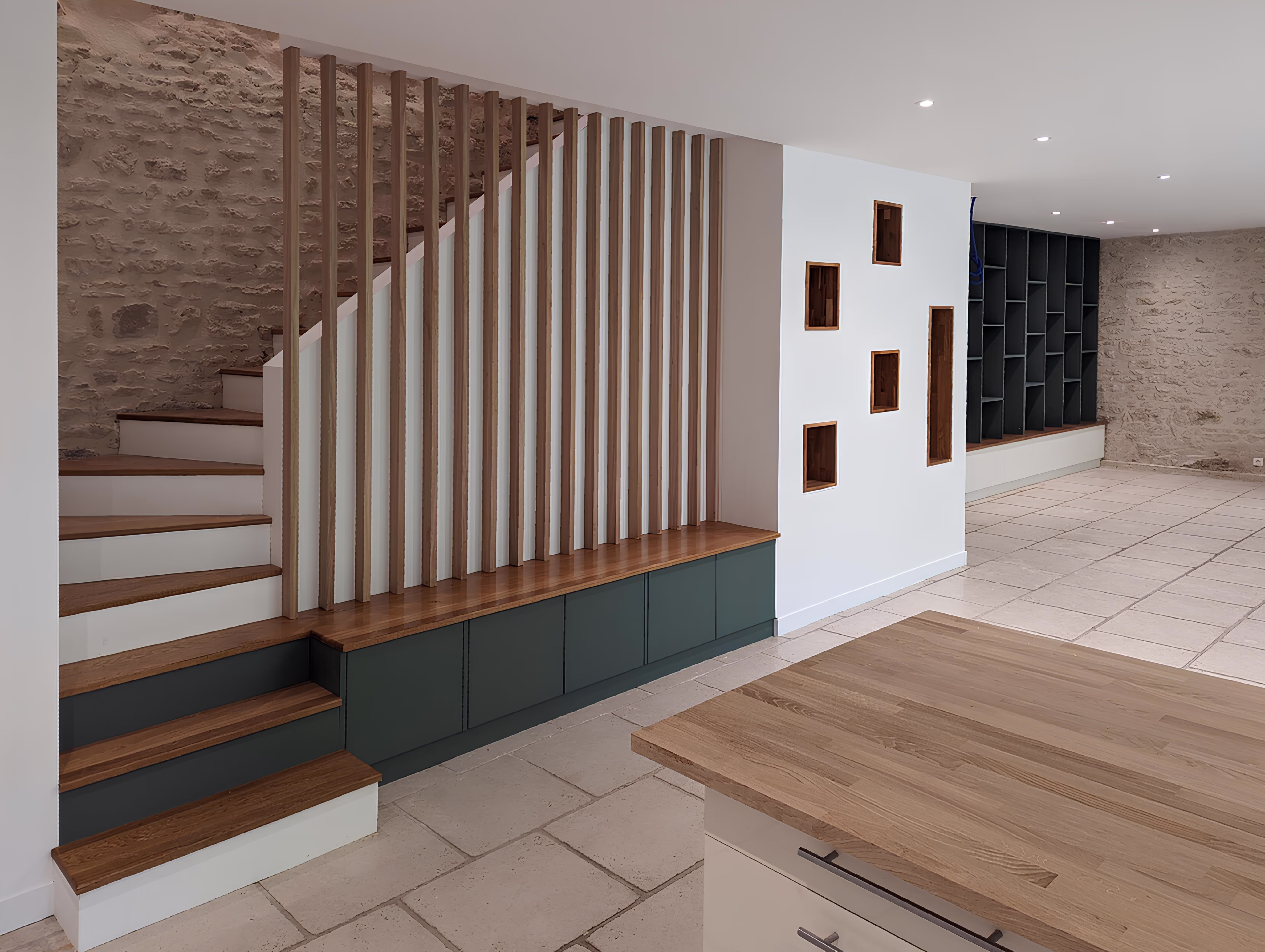 Photo réelle détaillant le nouvel escalier intérieur avec rangements intégrés et claustra bois, projet Longère de la Messe par SINA Architecture.