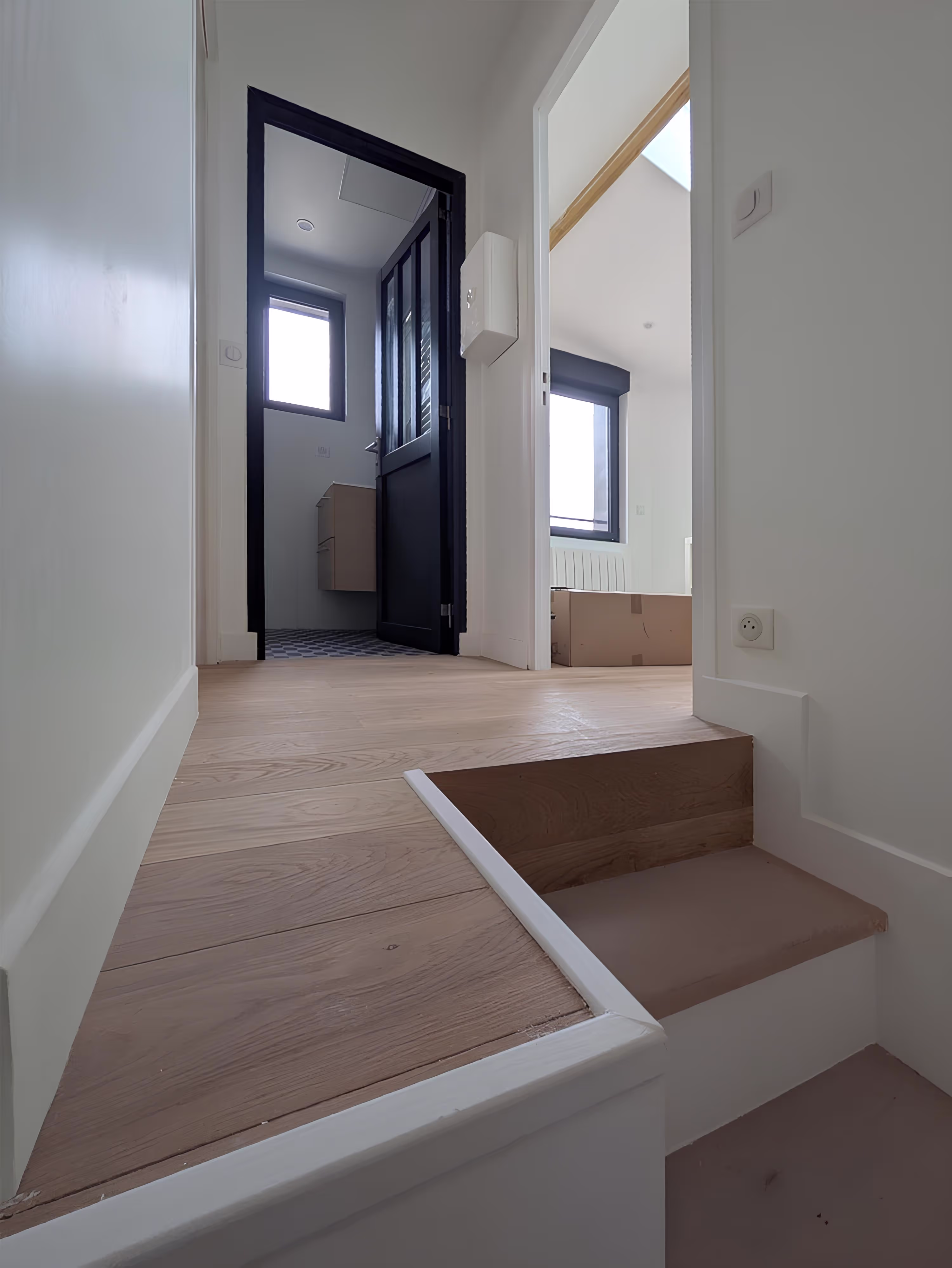 Vue intérieure sur le palier rénové desservant chambres et salle de bain, projet Surélévation Boileau par SINA Architecture.